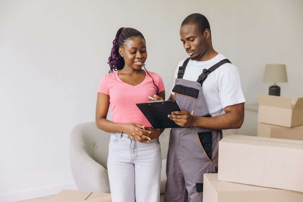 A Smyrna mover in overalls helping a customer by filling out paperwork