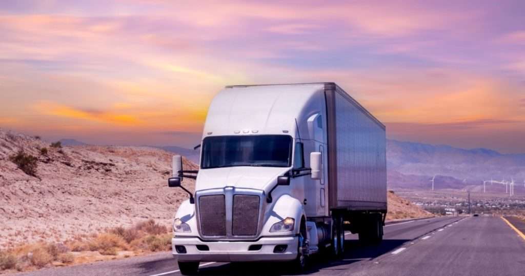 Moving truck driving at sunset.