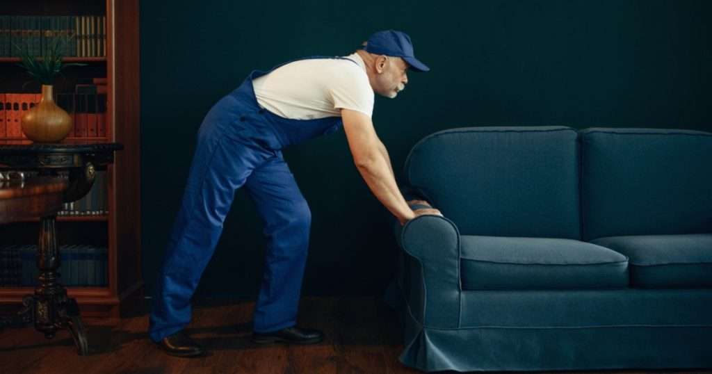 A professional with a moving company in Riverview DE moving a couch in a room