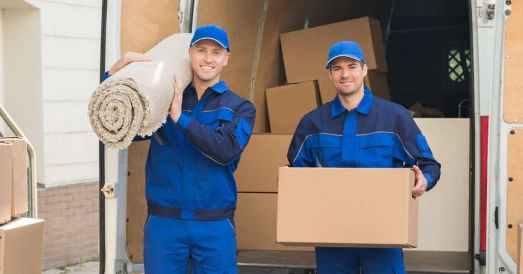 Two professionals from a Riverview DE moving company posing with boxes and rugs